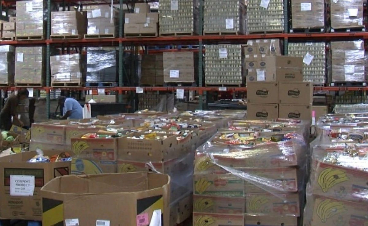 A food bank warehouse stacked with pallets and boxes of donated food